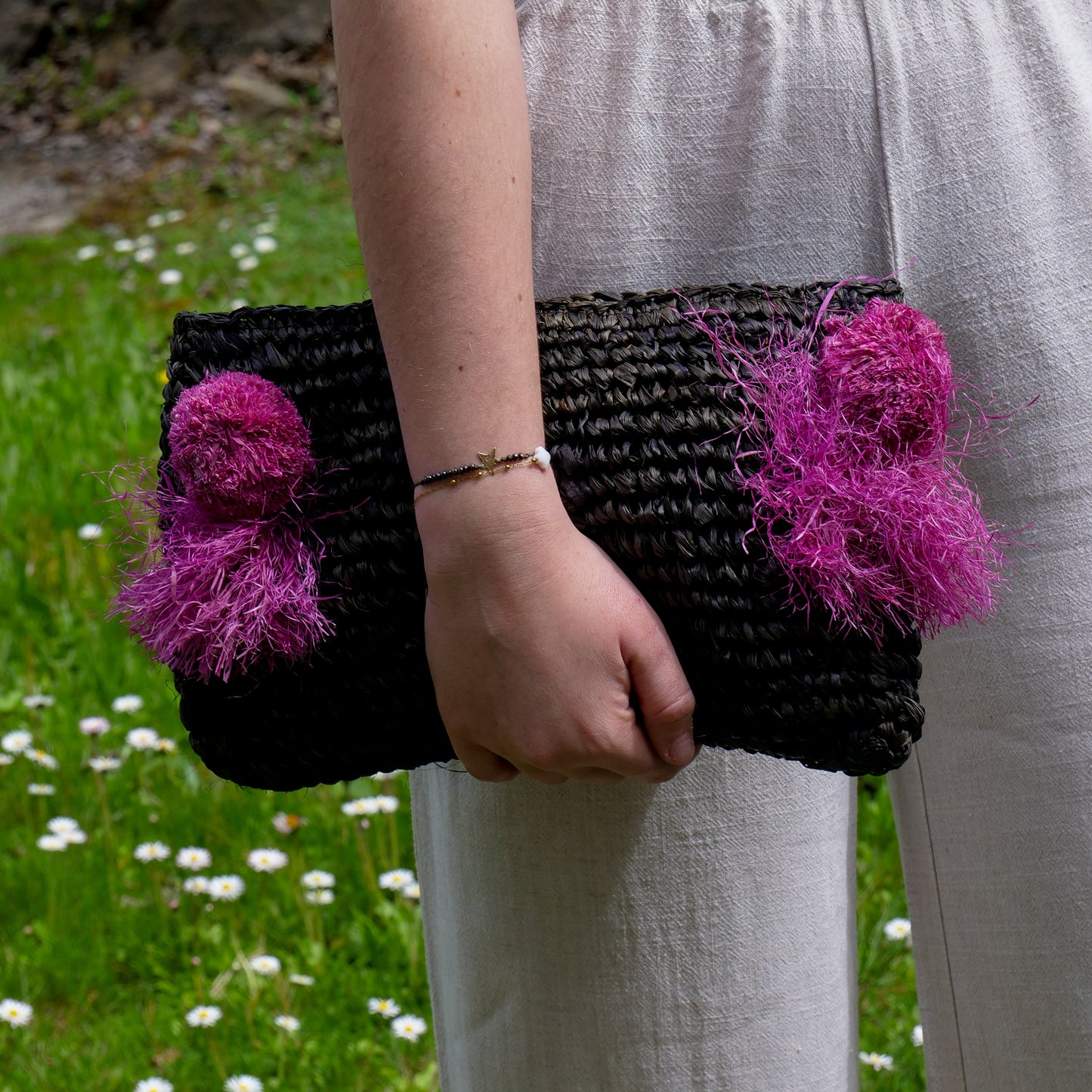 Pochette zippée en raphia noir, pompon rose