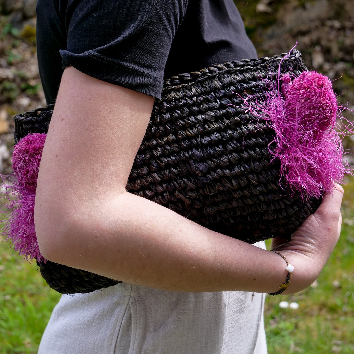 Pochette zippée en raphia noir, pompon rose