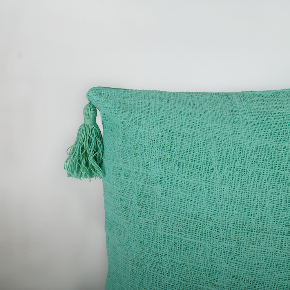 Housse de coussin turquoise avec pompons