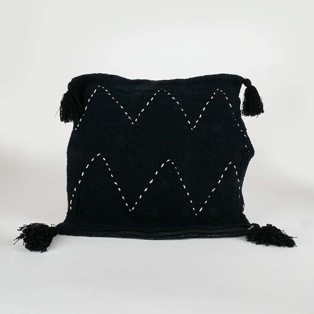 Housse de coussin noire à motifs blanc et pompons noir