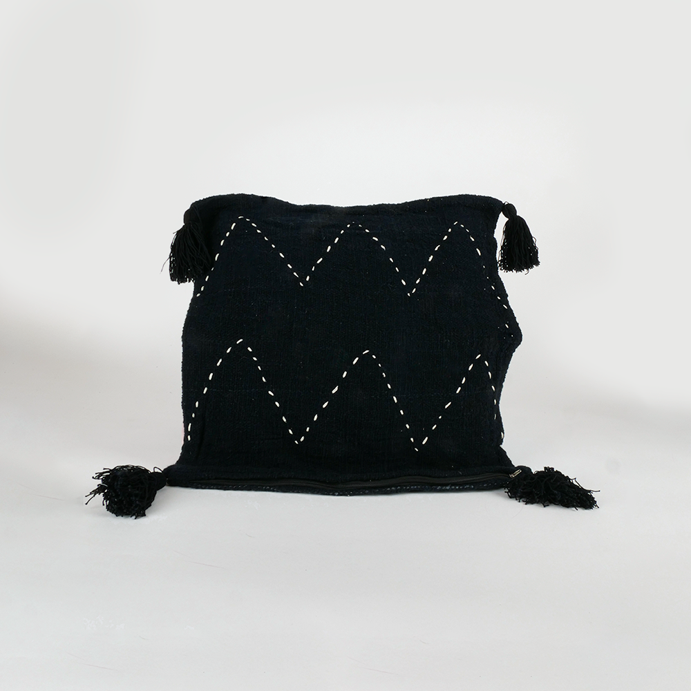 Housse de coussin noire à motifs blanc et pompons noir