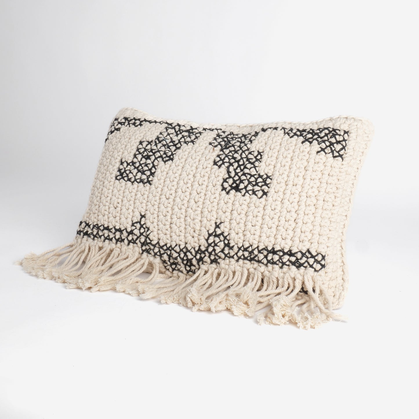 Coussin macramé garni blanc et noir avec franges et motifs géométriques