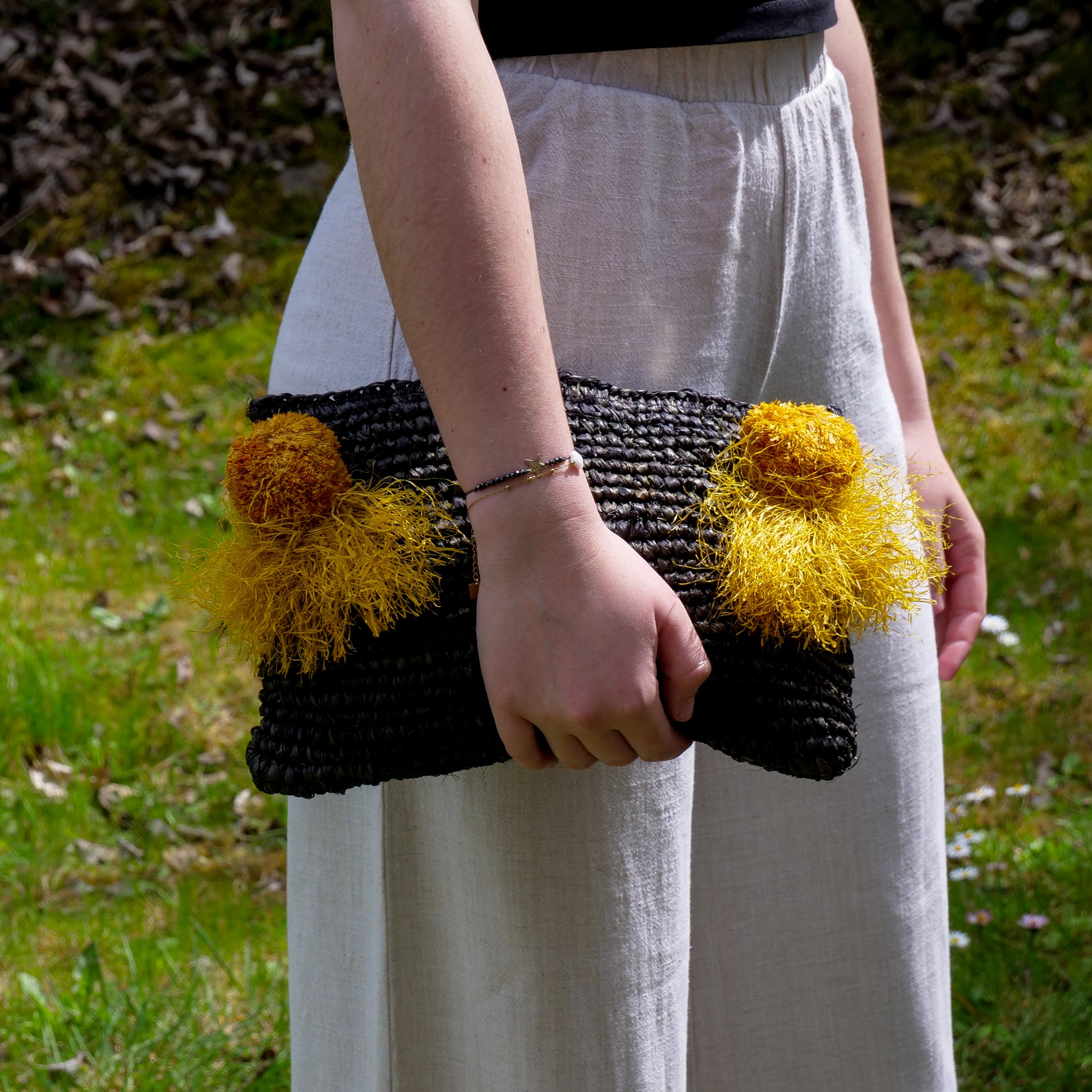 Pochette zippée en raphia noir, pompon jaune – SUD NOMADE