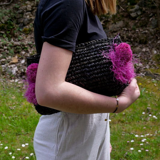 Pochette zippée en raphia noir, pompon rose