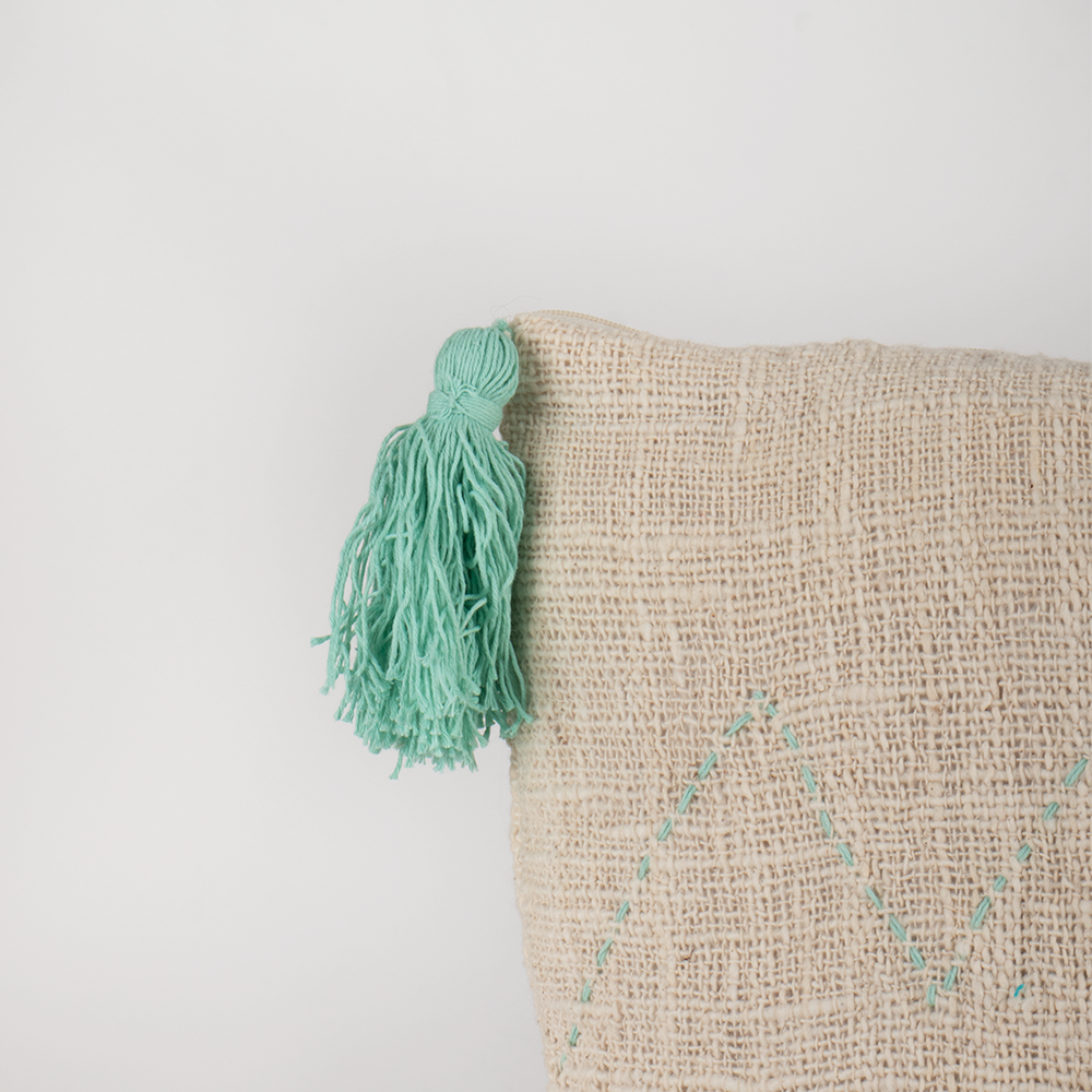 Housse de coussin écru motifs vert d'eau et pompons
