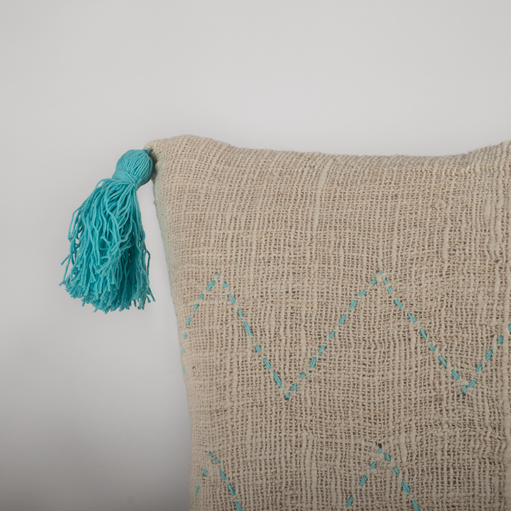 Housse de coussin écru surpiqûres et pompons turquoises 40x40