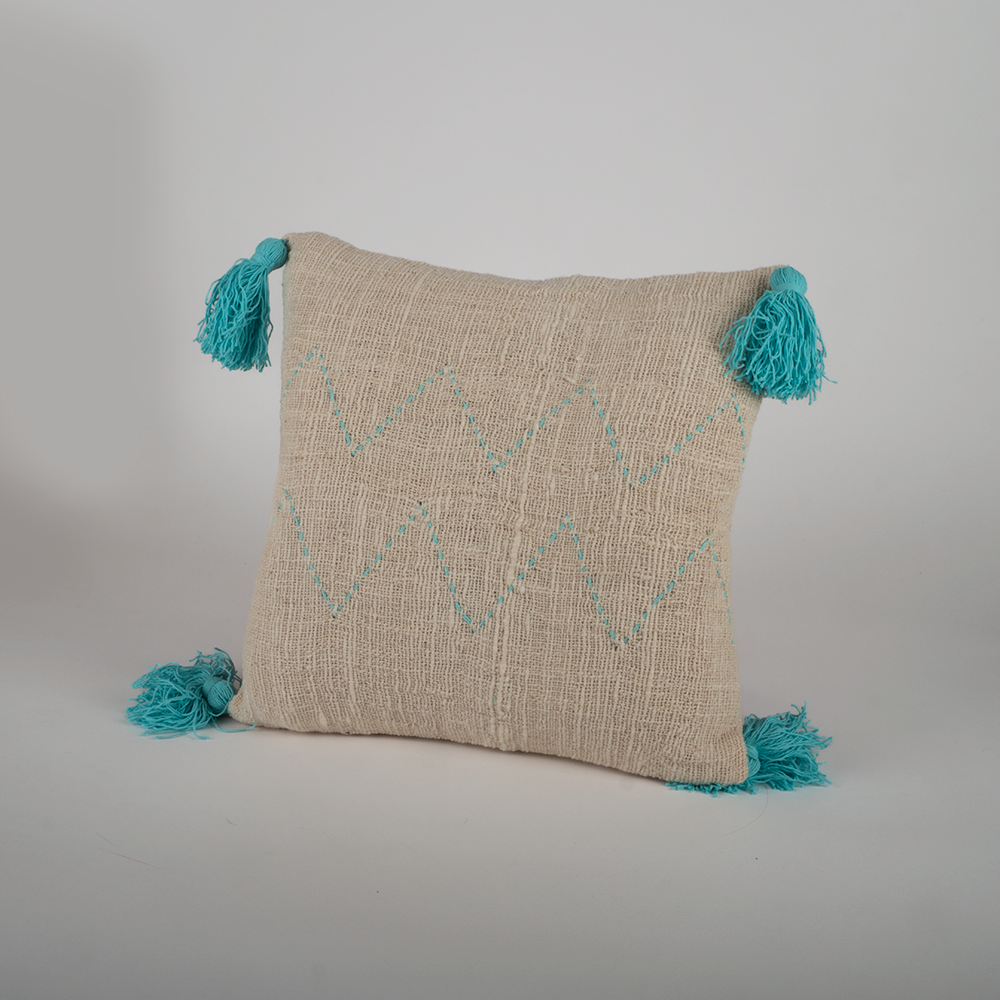 Housse de coussin écru motifs turquoise et pompons