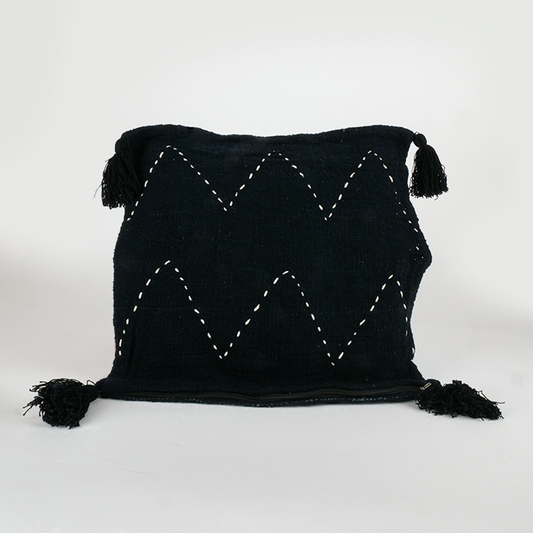 Housse de coussin noire surpiqûres blanches et pompons